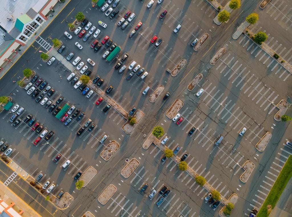 Air top view on of the parking lot for half empty on shopping mall the are cars on parking. (parking lot accidents blog)
