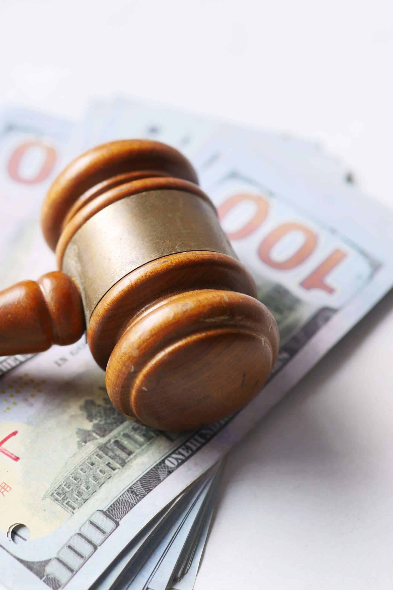 close up of gavel and cash on white background with copy space, side view