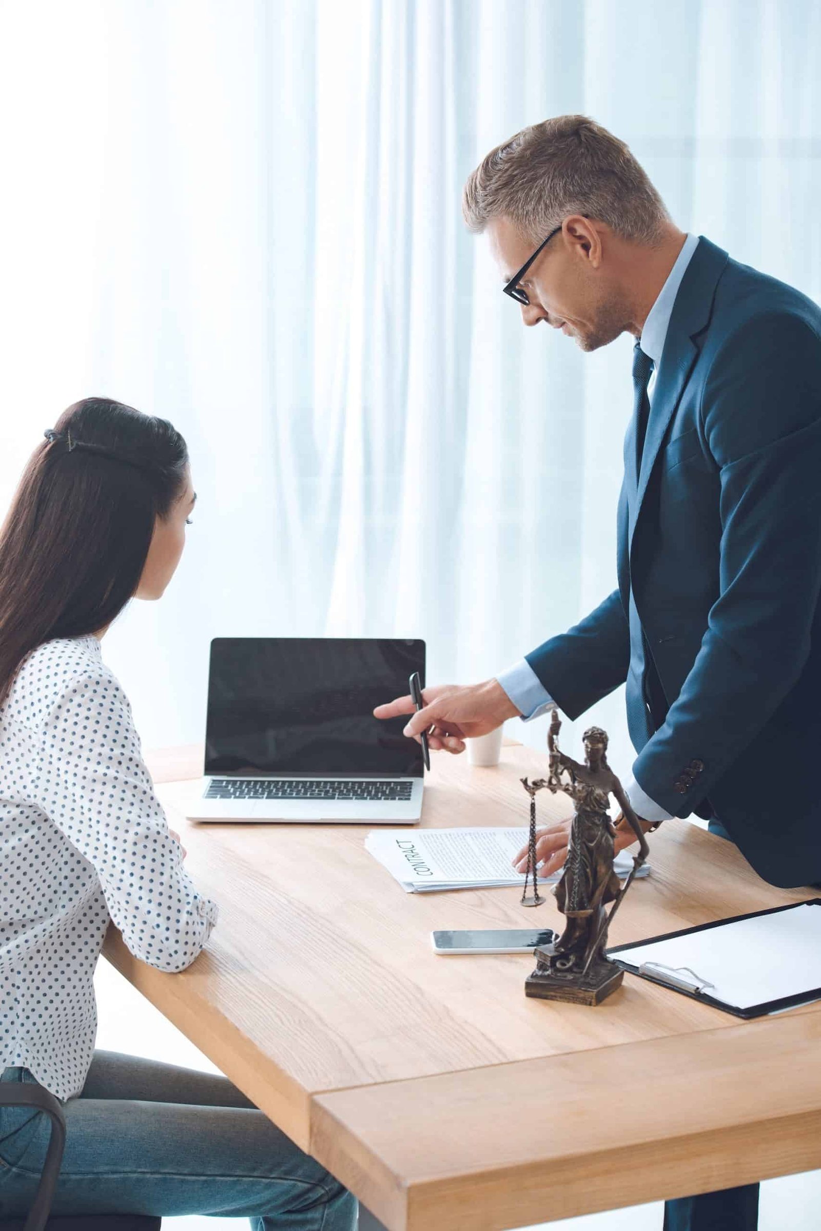 wrongful death lawyer working with young female client and pointing at laptop
