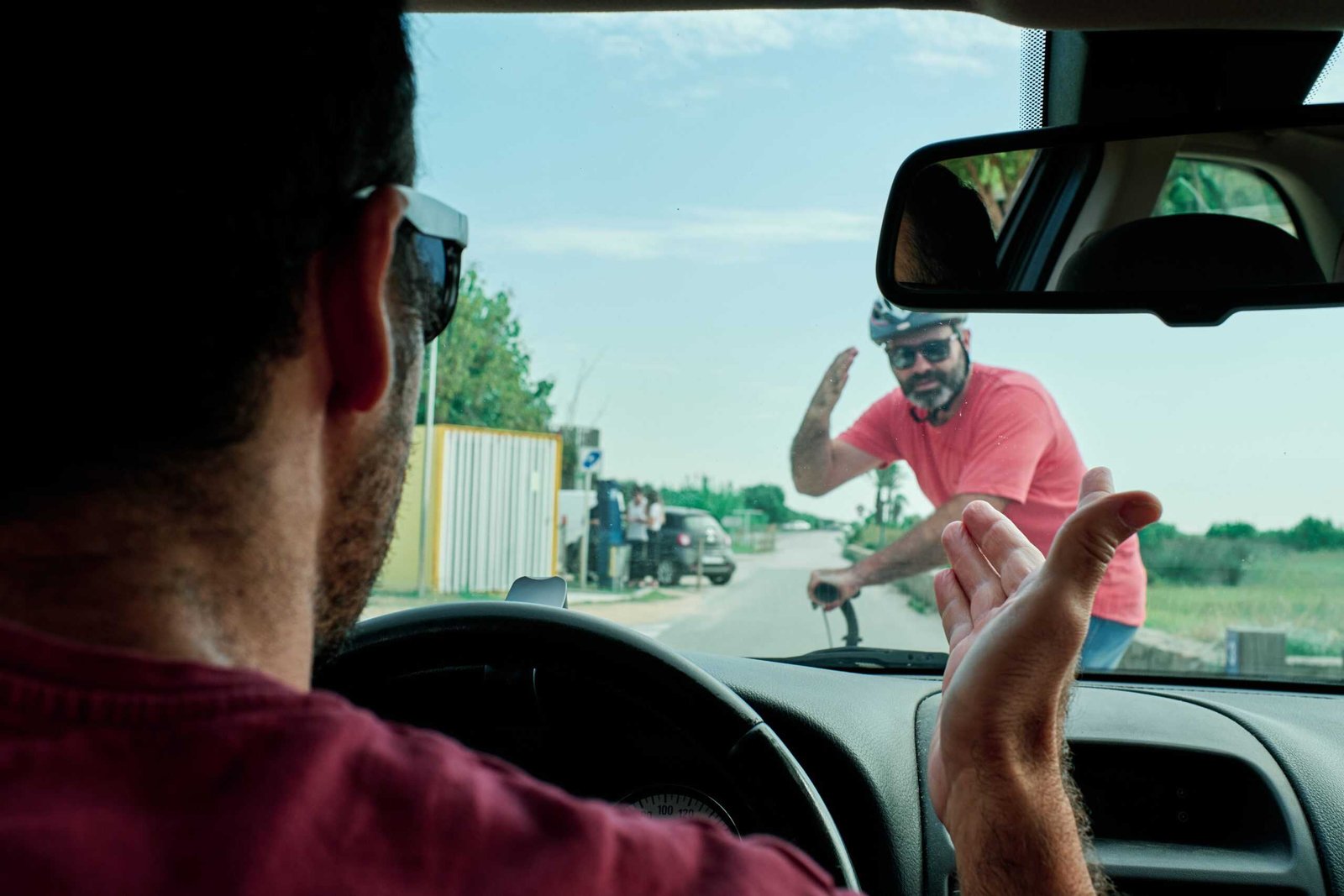 A driver aggressively arguing with a man on an electric scooter - leading cause of aggressive driving accidents