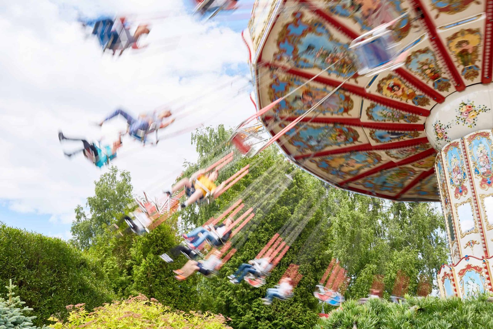 Children swinging on carousel at an amusement park.