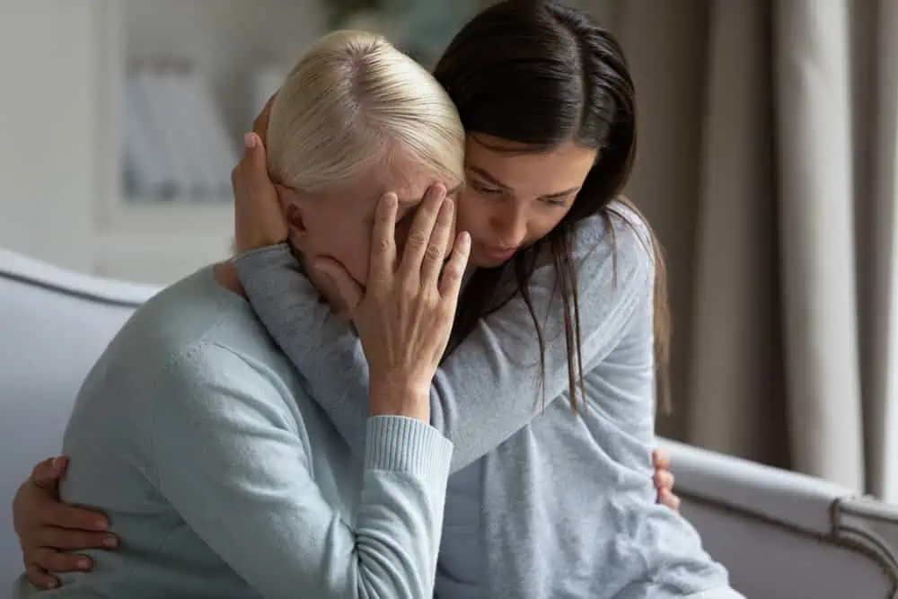Two women hugging and mourning the loss of a family member after a wrongful death accident.